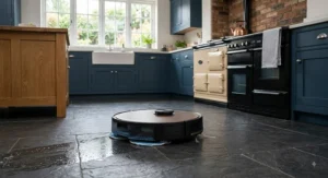 Dual-action premium robot vacuum mopping and sweeping slate tiles in a British kitchen.